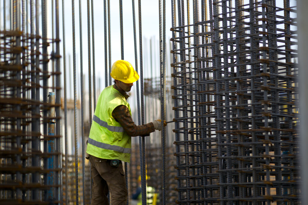 Homem trabalhando no canteiro de obras utilizando soluções em aço sob medida